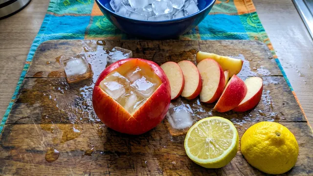 Apple slices, lemon and ice on a cutting board